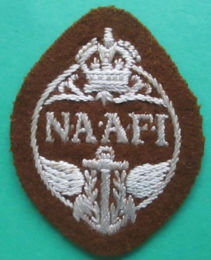 A WWII BROWN AND WHITE NAAFI UNIFORM / CAP BADGE