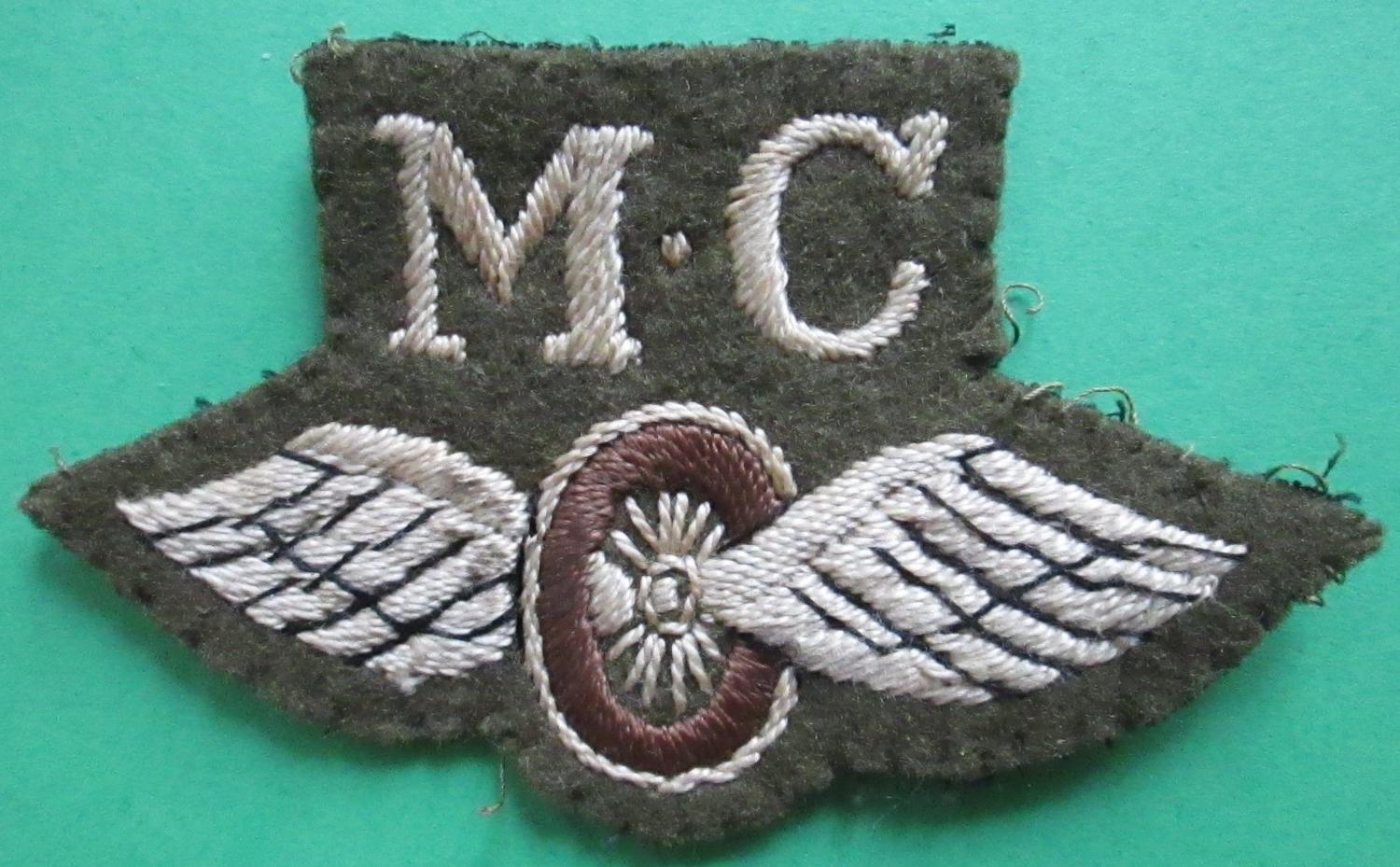 A WWII MOTOR CYCLE WINGS AND WHEEL BADGE