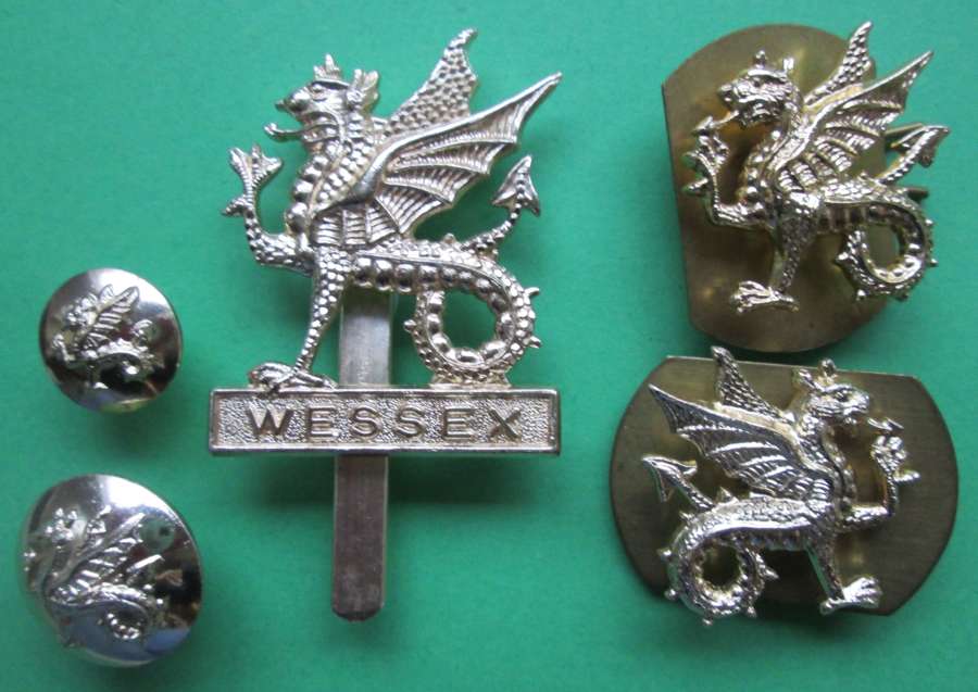 AN ANODISED ALLOY WESSEX REGT CAP BADGE AND COLLAR BADGES