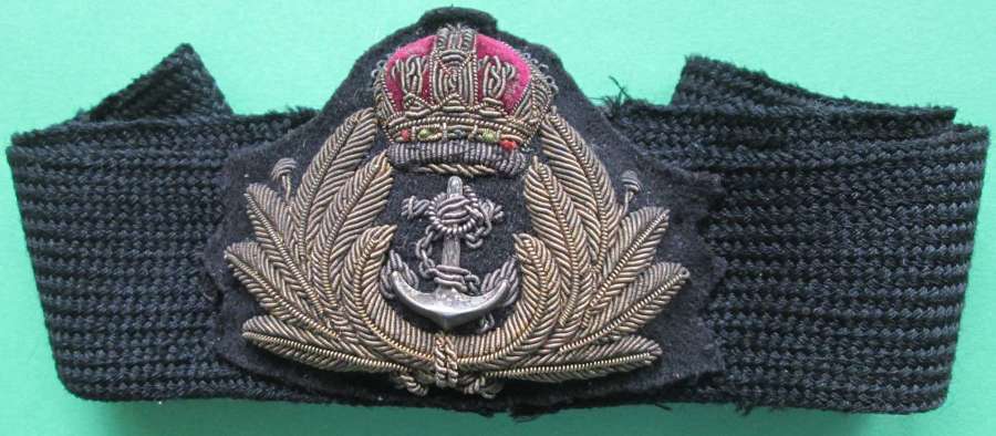 A ROYAL NAVAL OFFICER'S CAP BADGE AND BAND